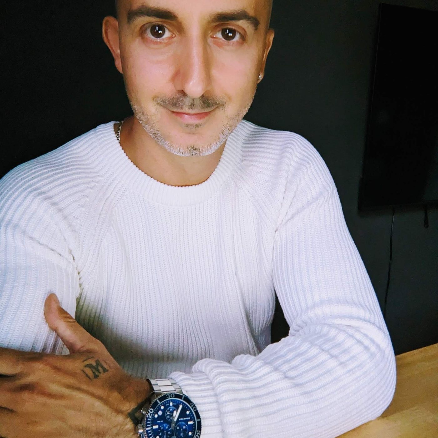 Rob Toth smiling at the camera in a white sweater